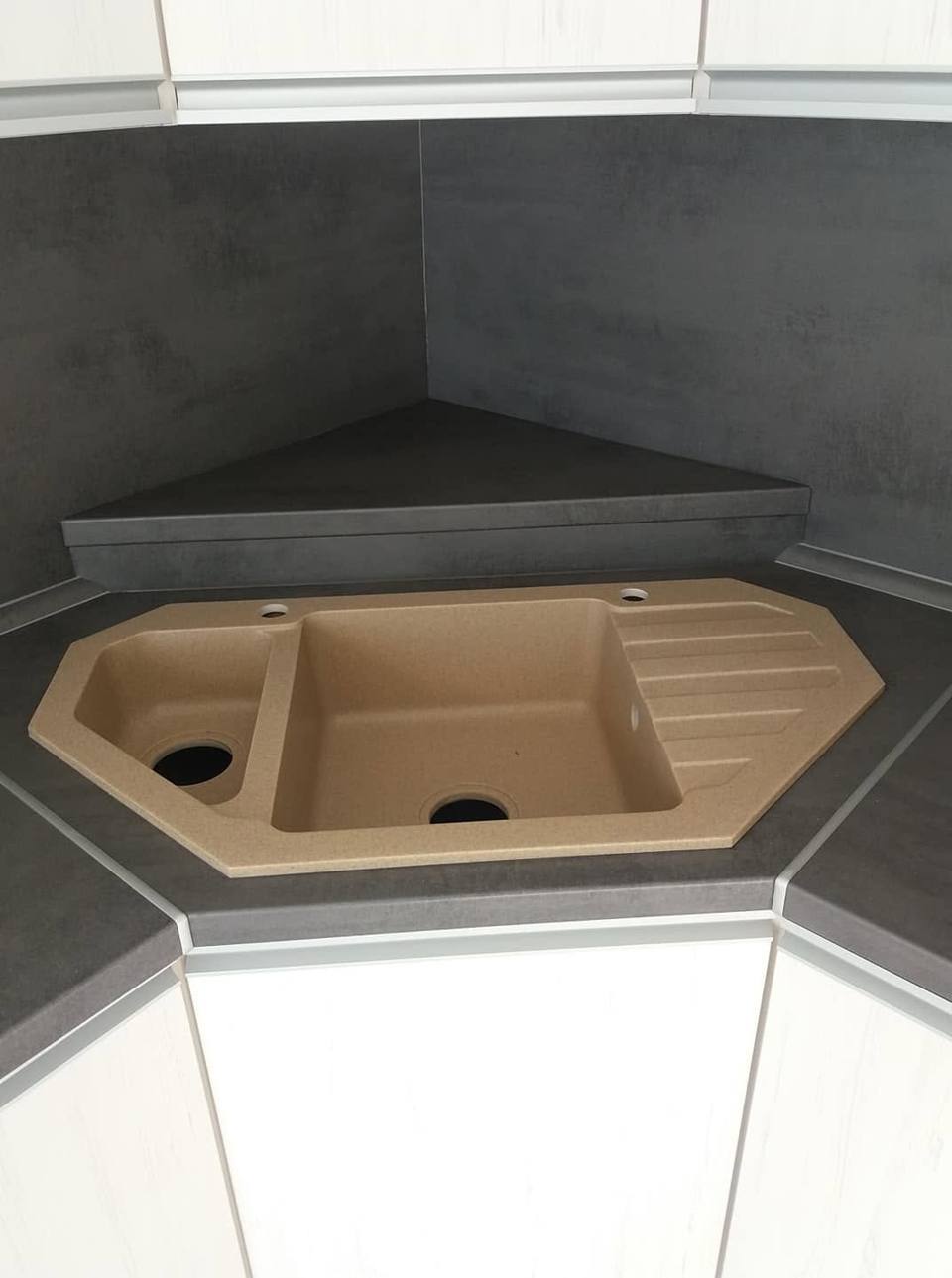Beige Eckspüle aus Granit in der anthrazitfarbenen Arbeitsplatte
