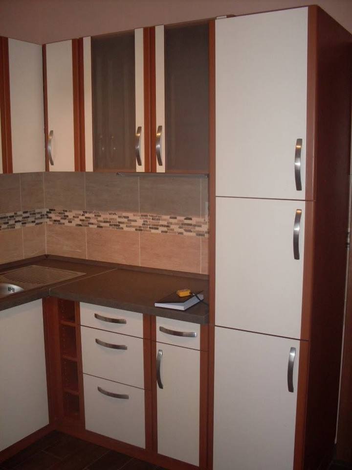 Weiße Laden, offenes Regal und hoher weißer Kasten mit Holzdekor
