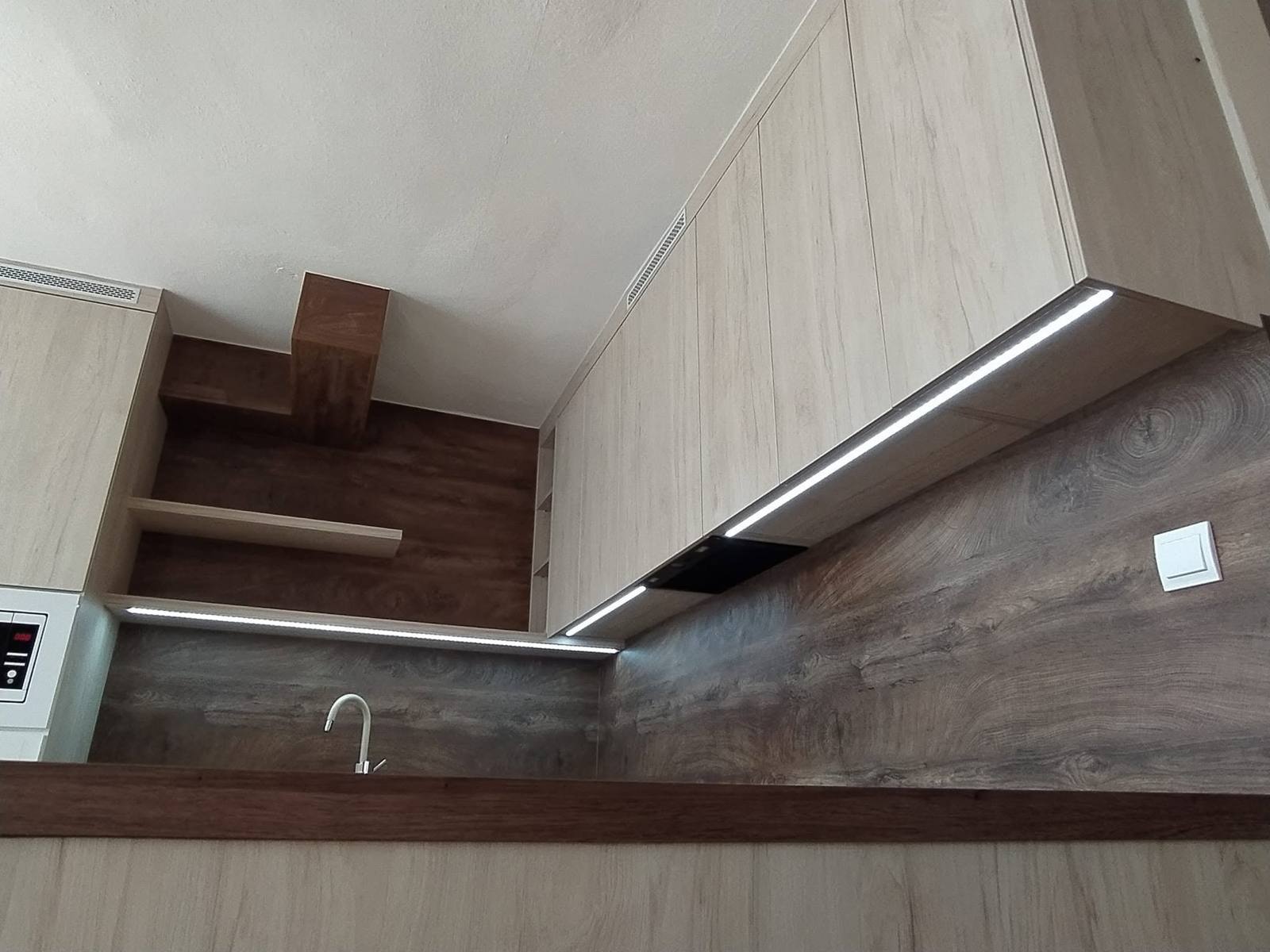 Dunkle Eichenborde in der Ecke unter hellen Oberkästen mit LED