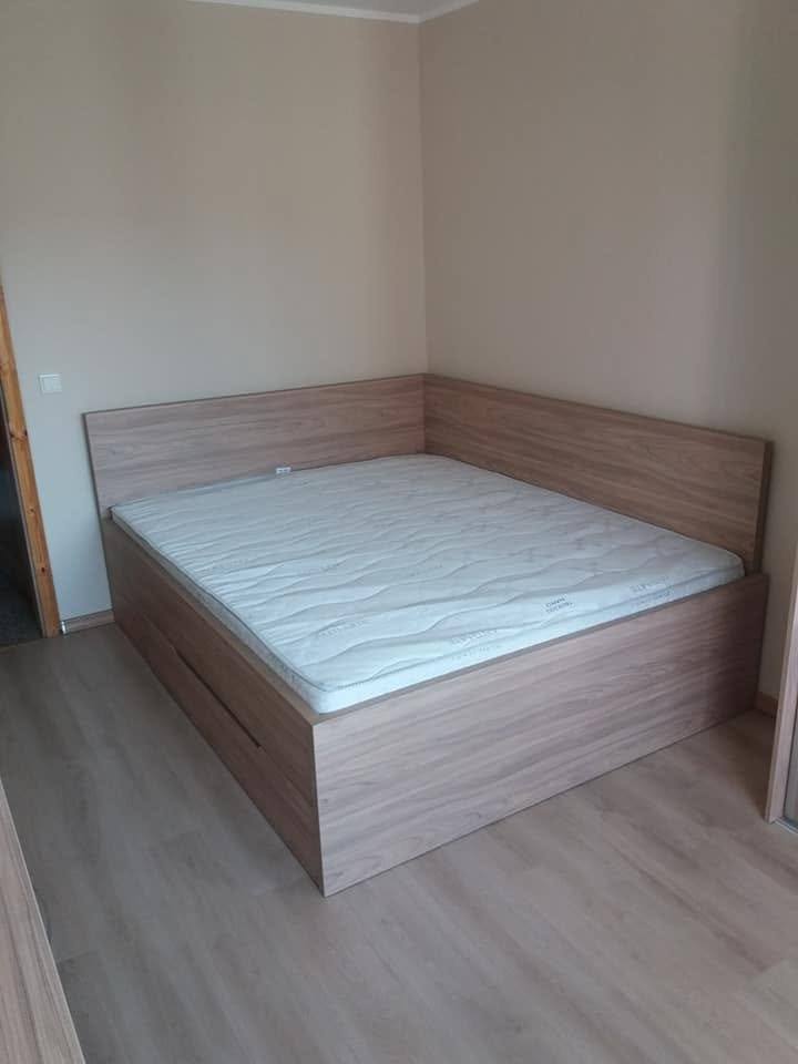 Doppelbett mit Matratze und Kopfteil entlang zweier Wände