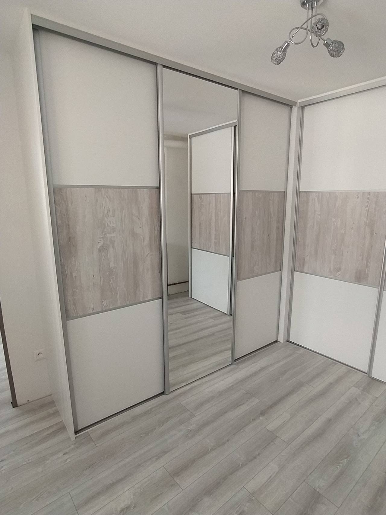 Linker Schenkel des Eckkastens mit Spiegeltür und grauem Streifen