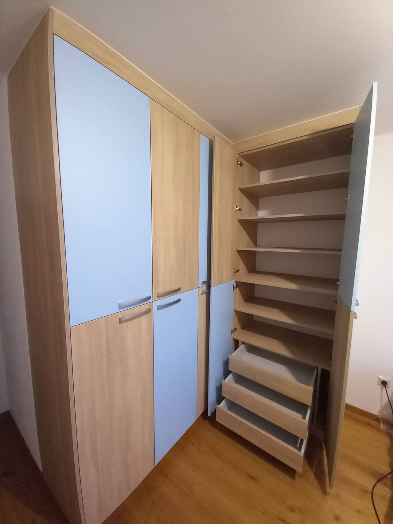 Geöffnete Tür mit Fachböden in Eiche und herausgezogenen Laden