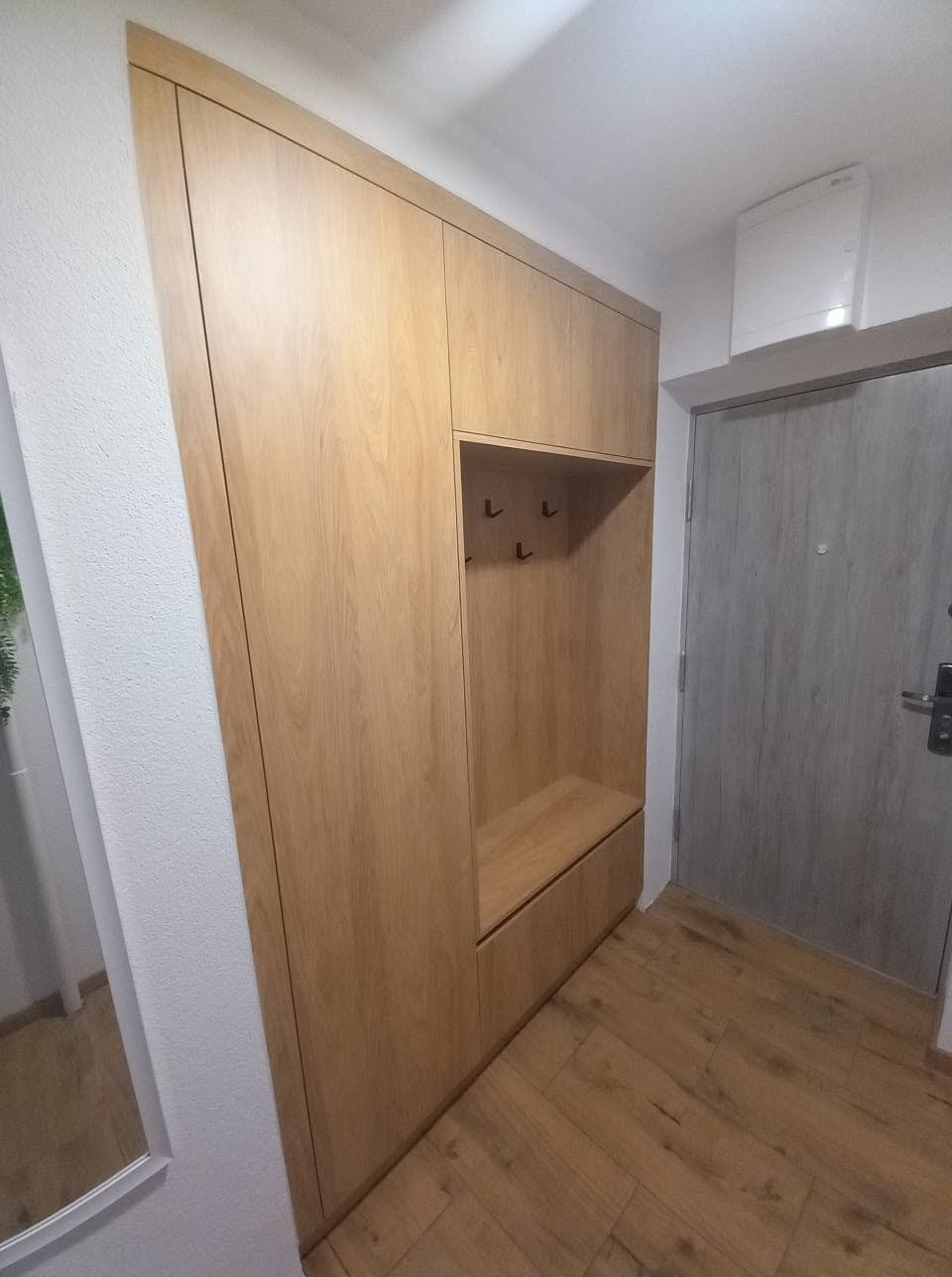 Eckkasten in Eichendekor mit kleiner Garderobennische und Haken seitlich.