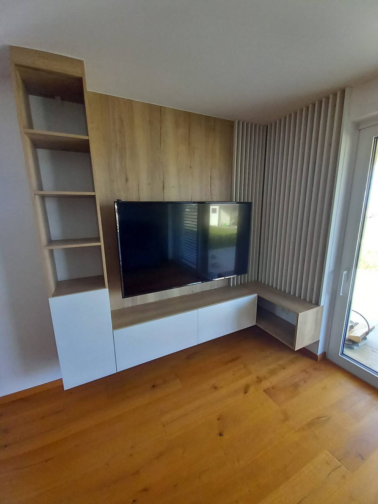 Eichen-TV-Wand mit Borden und grauen Lamellen in der Zimmerecke