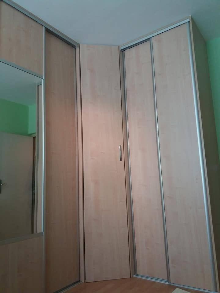 Spiegeltür des Eckkastens mit Holzdekor an den Seiten.