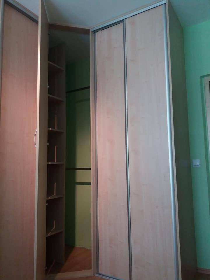 Geöffneter Eckkasten mit leerem Innenraum an der grünen Wand.