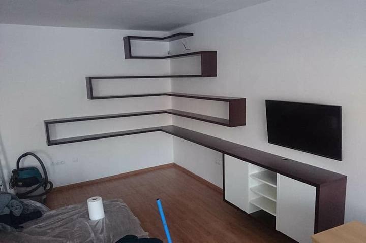 Eckkombination aus dunklen Wandregalen und TV-Kästchen im Wohnzimmer