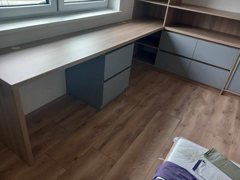 Rohová pracovná zostava so sivými zásuvkami a policami
