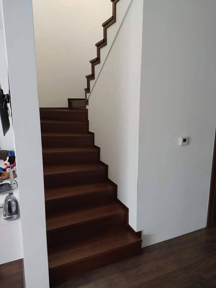 Dunkle Eichenstiege entlang der weißen Wand von unten gesehen