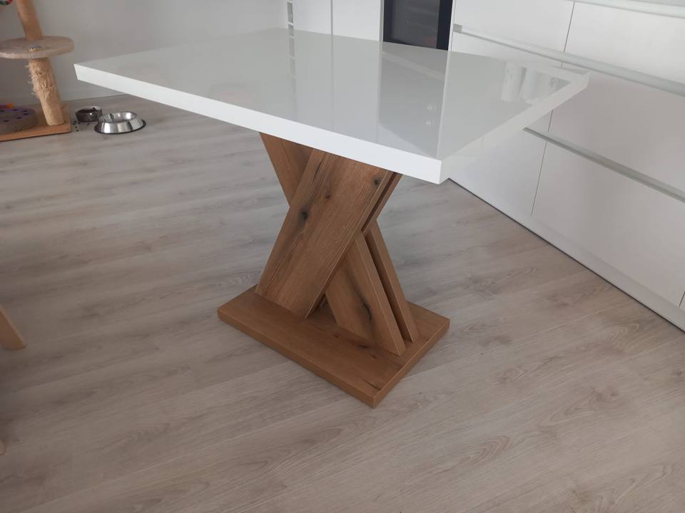 Esstisch mit glänzend weißer Platte und massivem Kreuzbein