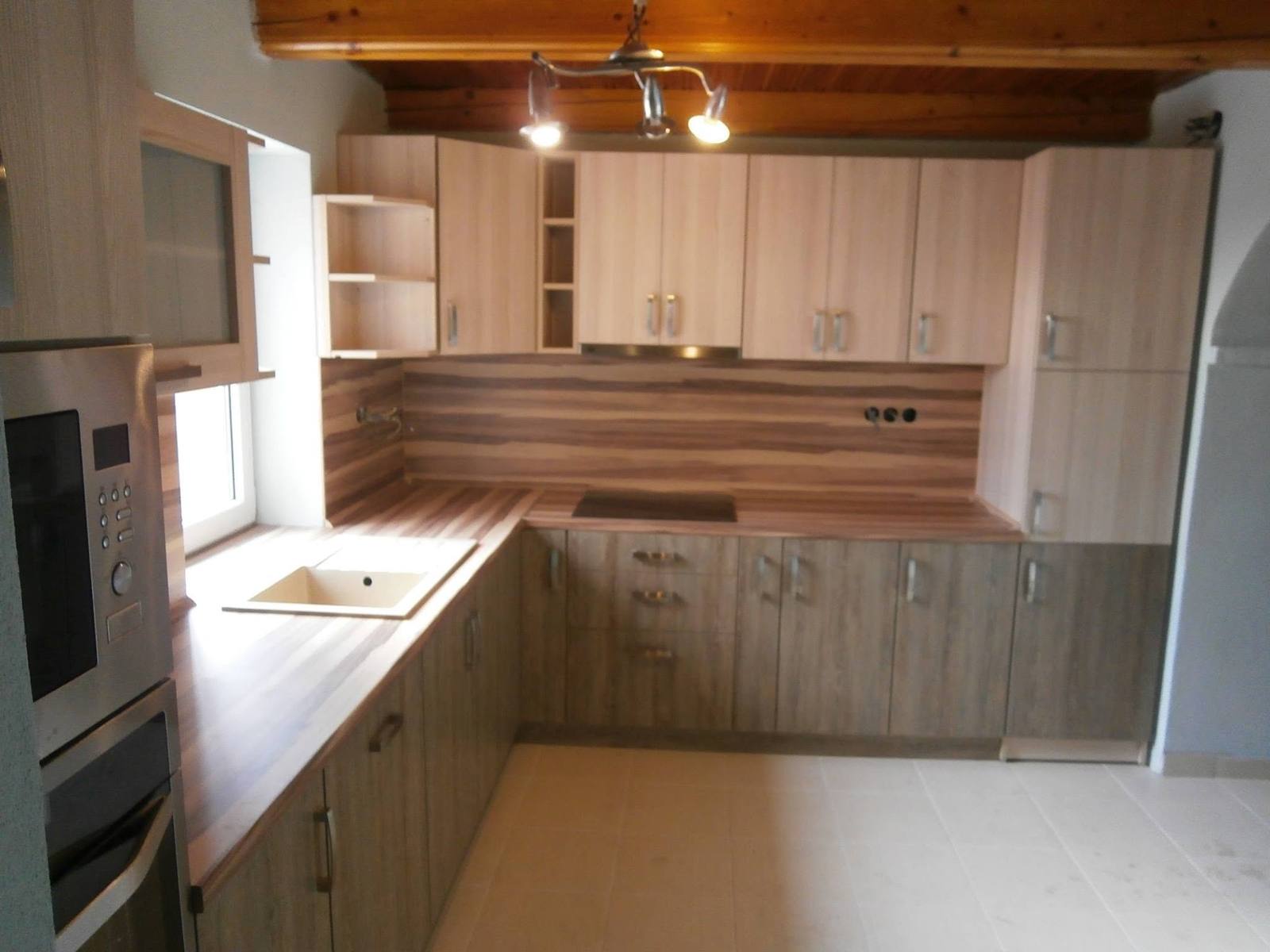 Eckküche in Holzdekor mit Borden unter der Holzdecke