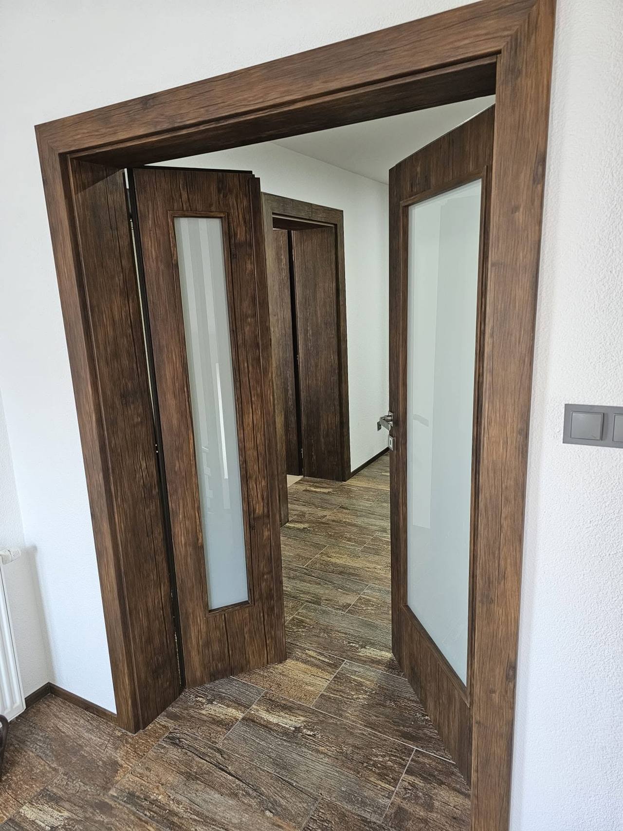 Geöffnete zweiflügelige rustikale Tür mit Blick in den Flur