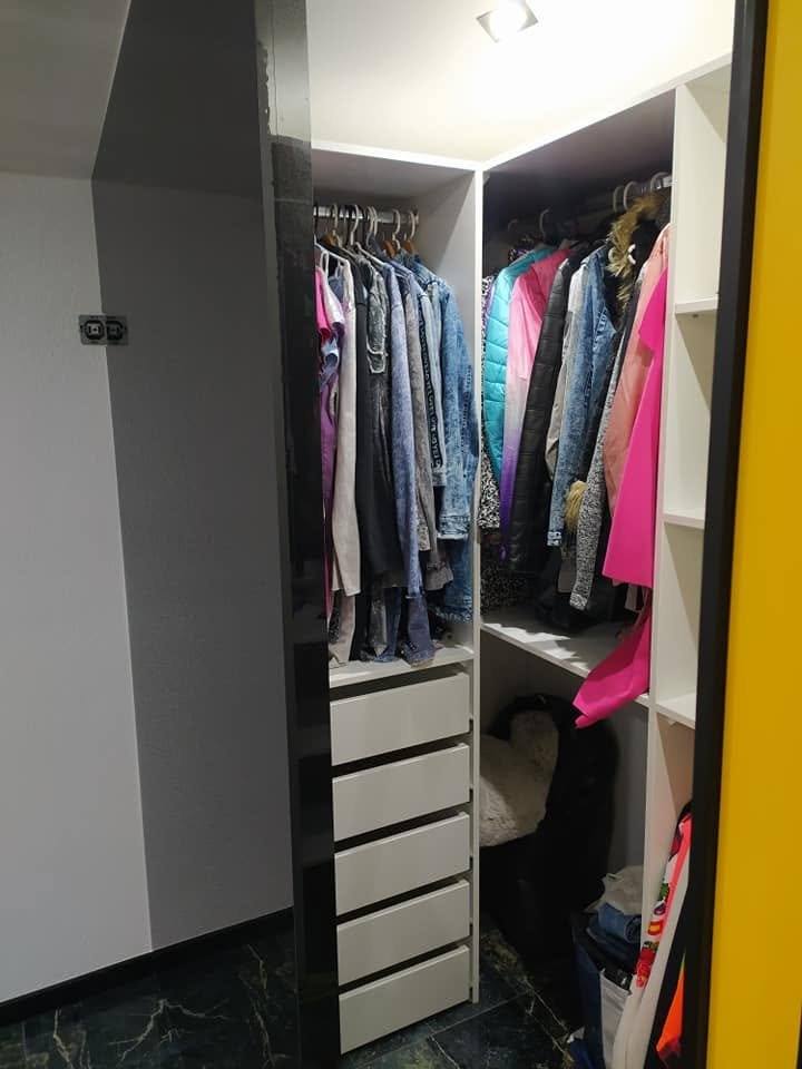 Šatníková skriňa so zrkadlom, tyčou na vešiaky a zásuvkami.