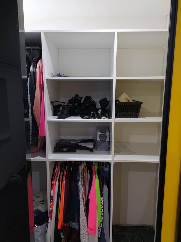 Weiße offene Böden mit Fächern für Schuhe und Kleidung.