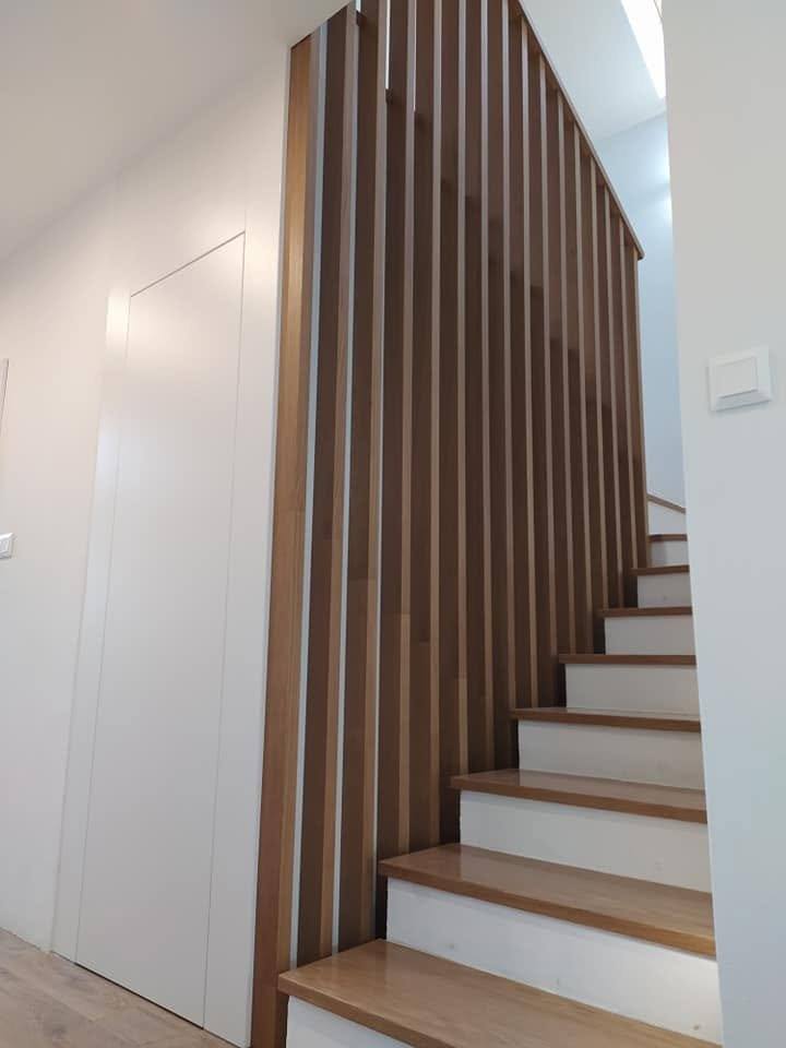 Eichenstiege mit Lamellenwand und weißen Setzstufen