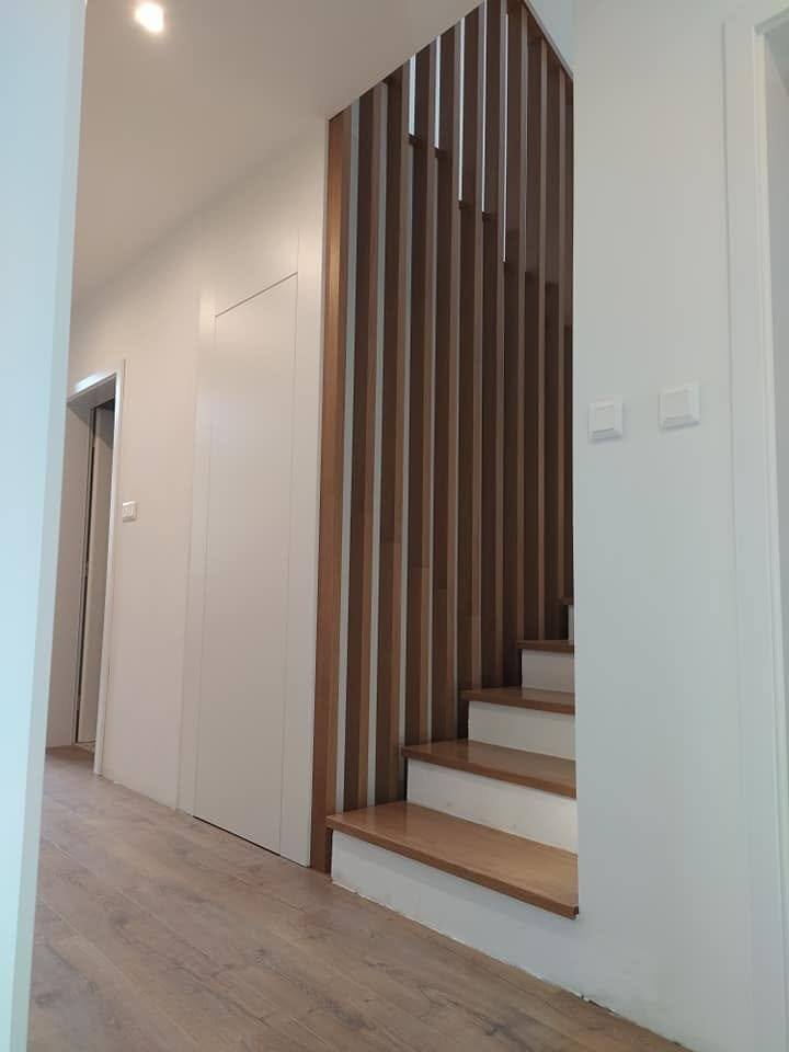 Blick auf die Lamellenwand entlang der Stiege zur Tür