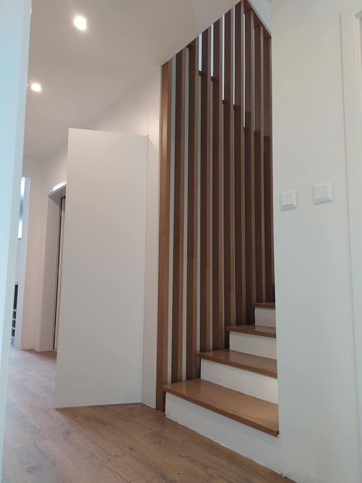 Senkrechte Eichenlamellen trennen die Stiege vom Vorzimmer