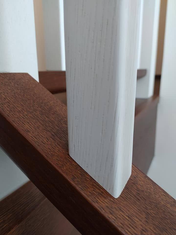 Detail des dunklen Holzhandlaufs mit gerundetem Profil