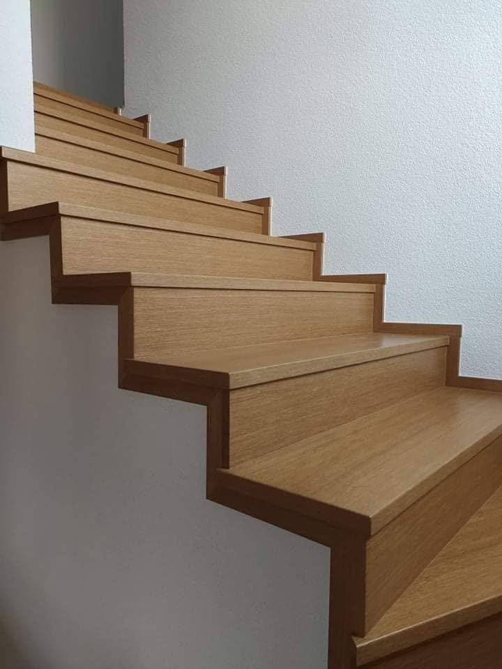 Stiege in heller Eiche mit Sockelleiste an der Wand beim Heizkörper