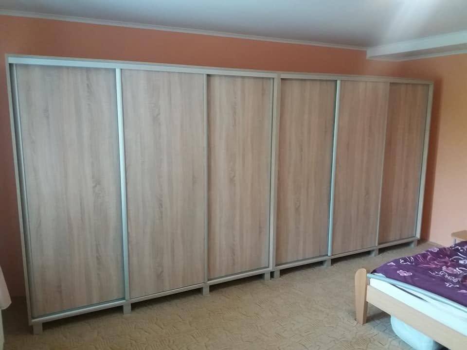Breiter Einbaukasten mit vier Türen neben dem Bett im Schlafzimmer.