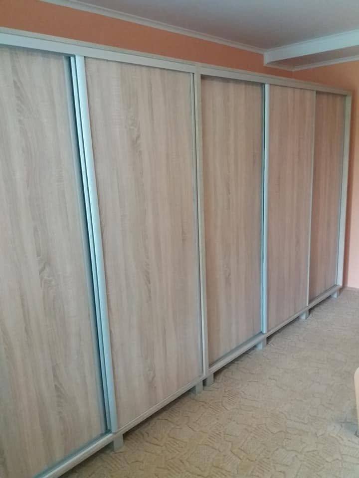 Detail der Ecke des breiten Kastens mit Schiebetüren in Holzdekor.