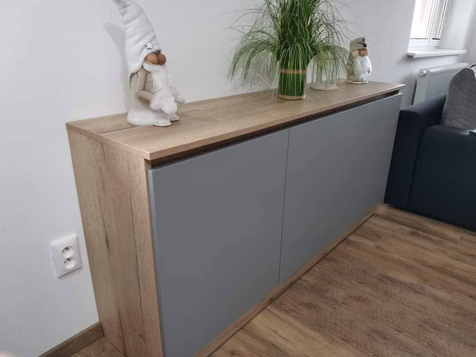 Graue Kommode im Rahmen in Eichenoptik neben dem Sofa