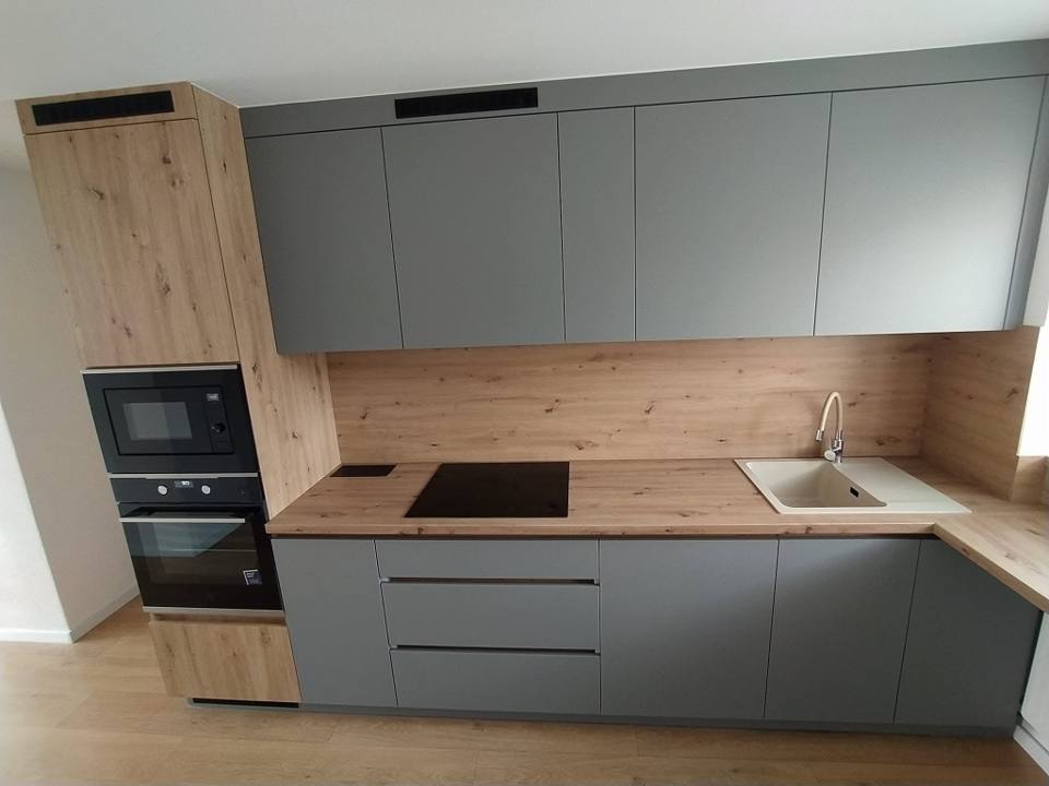 Graue L-Küche mit Eichenrückwand und Hochschrank