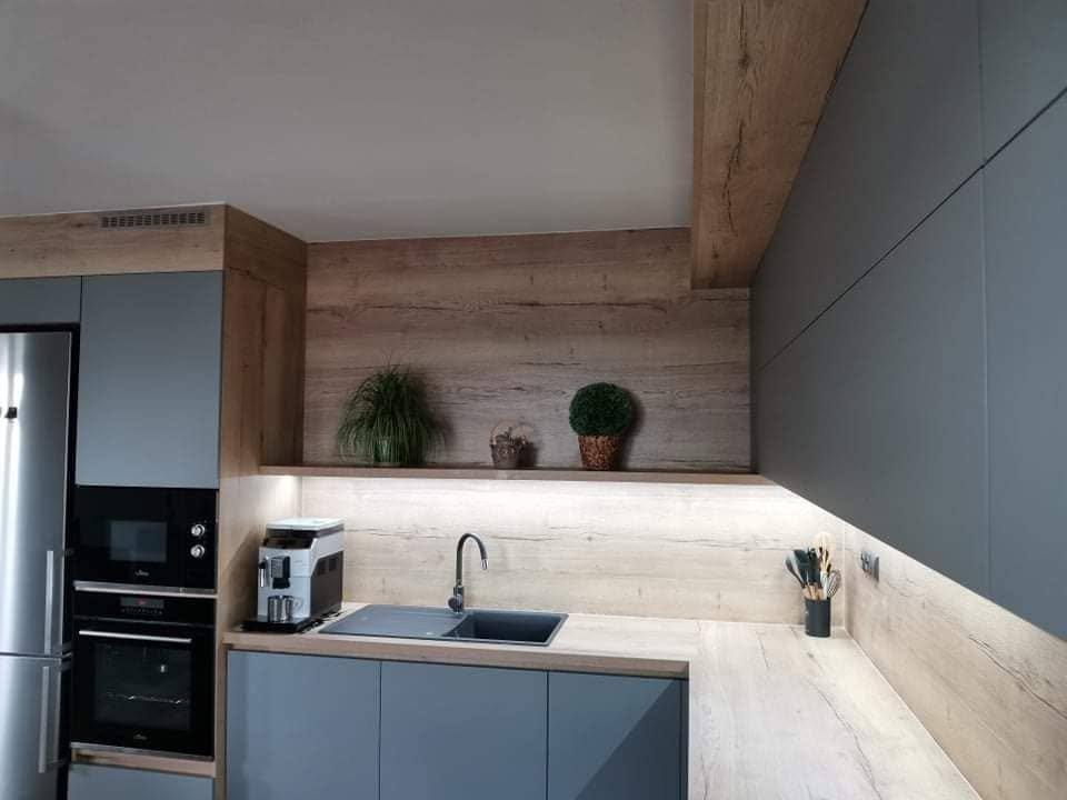 Zeile mit Spüle, beleuchteter Rückwand und Regal mit Pflanzen