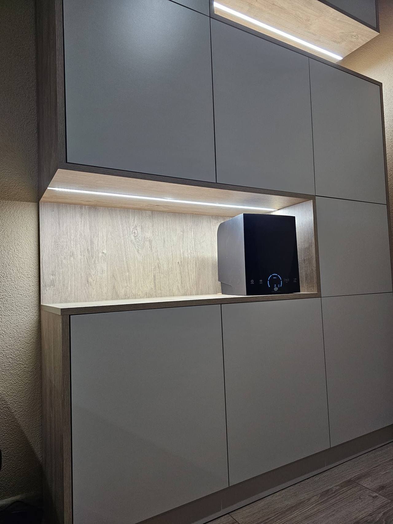Graue Stauwand mit beleuchteter Eichennische unter der Dachschräge