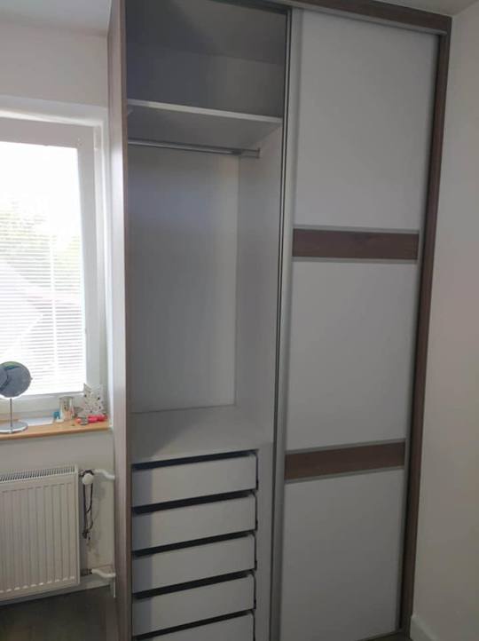 Grauer Schiebetürkasten mit Eichenstreifen und ausgezogenen Laden.
