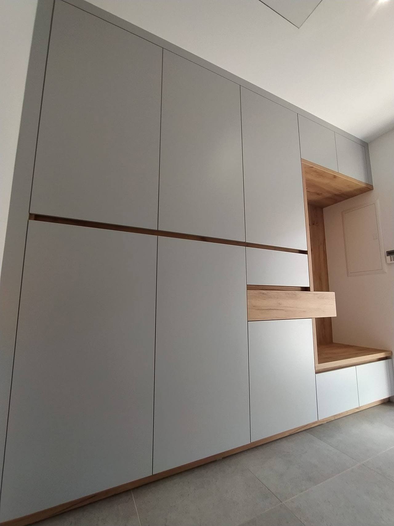 Hellgraue Kästen bis zur Decke mit Griffleiste in Eiche