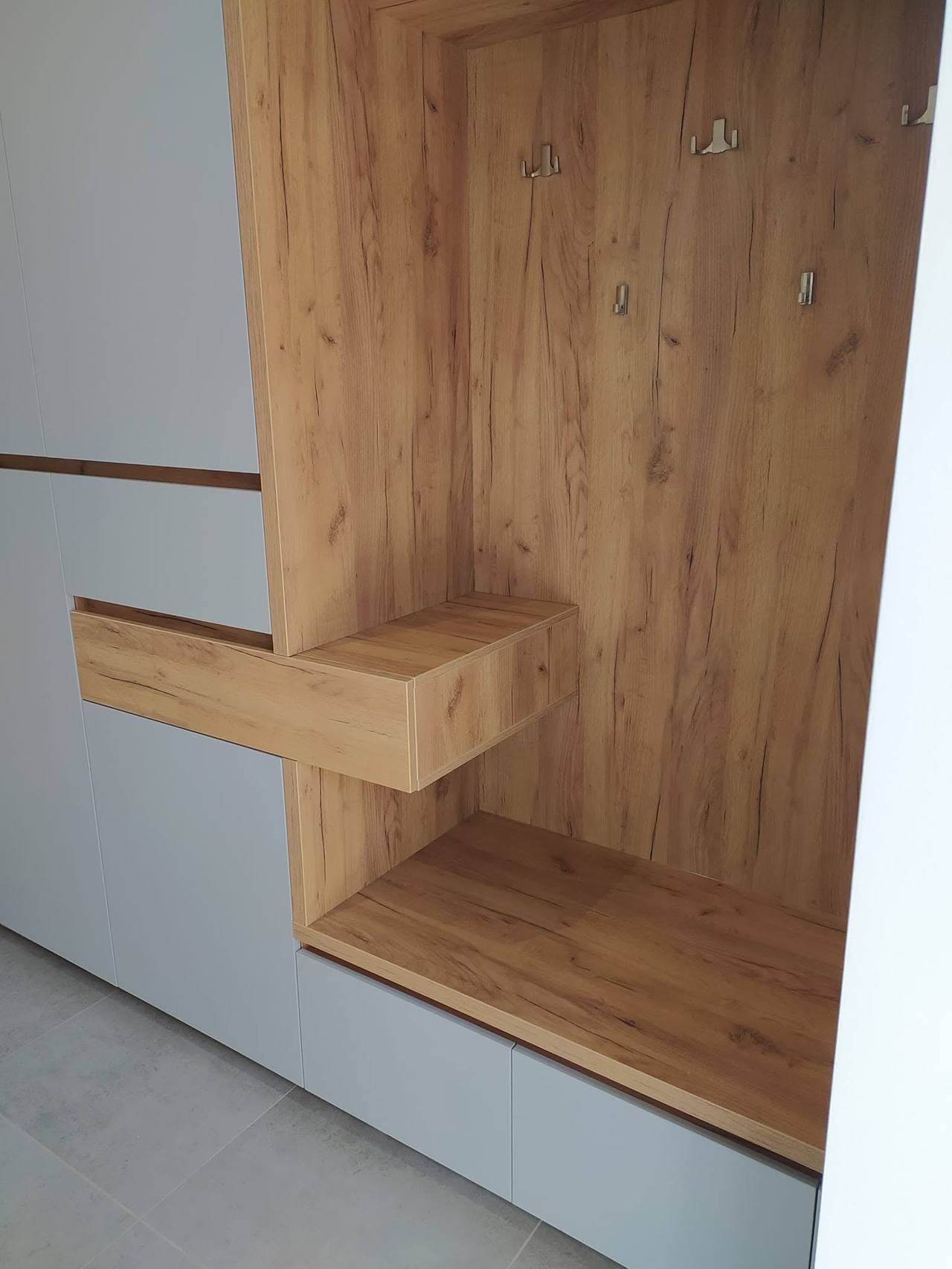 Detail der auskragenden Eichenablage und der Haken in der Nische