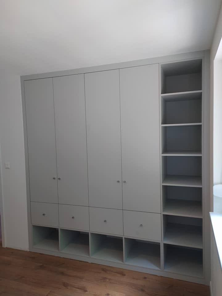 Graue Kastenwand mit unteren Fächern und offenem Seitenregal