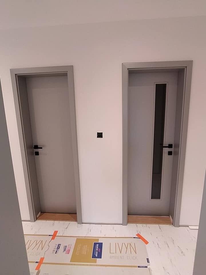 Zwei graue Innentüren, eine mit schmalem senkrechtem Glas