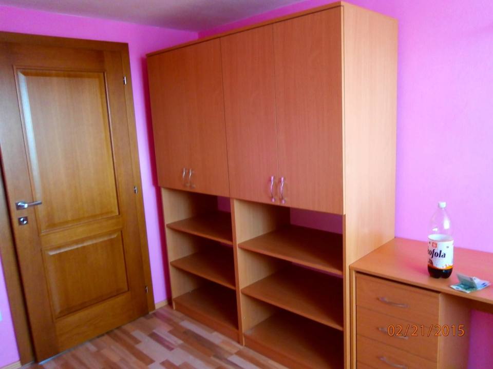 Kasten in Kirschbaumoptik mit offenen Borden vor rosa Wand