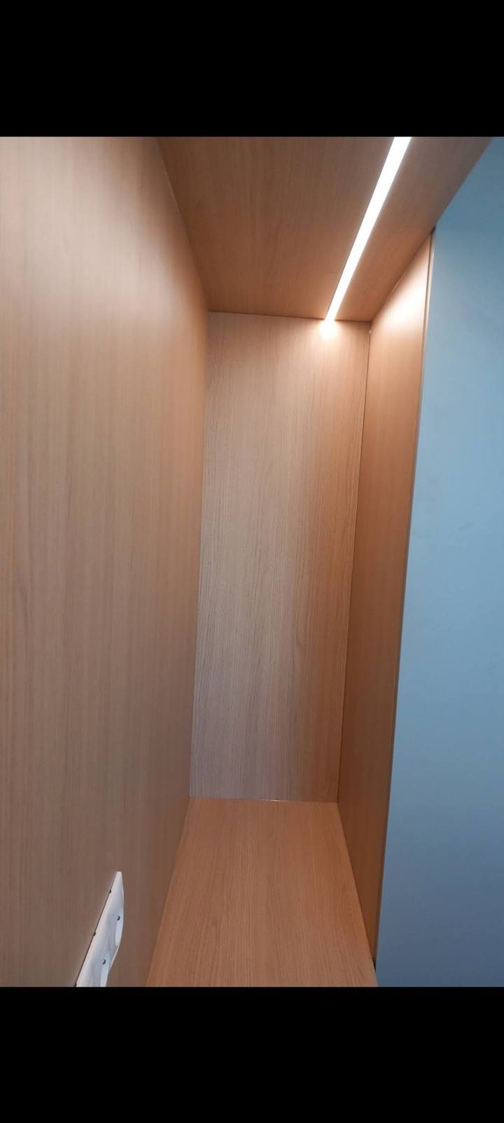 Schmaler Kleiderkasten im Eichendekor mit LED-Streifen an der Decke