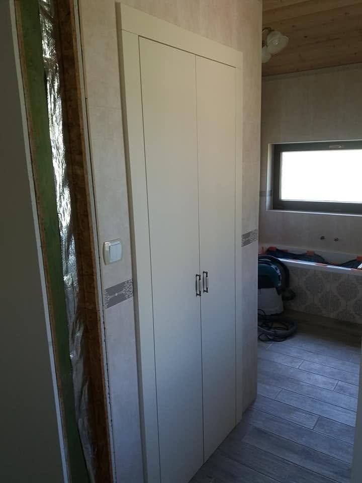 Weißer zweitüriger Einbaukasten steht im Vorzimmer