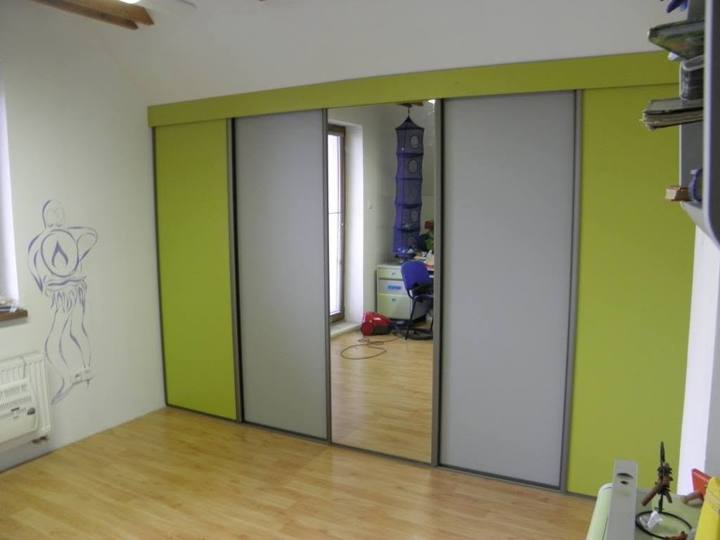 Schwebetürenkasten mit grünen und verspiegelten Türen im Dachzimmer