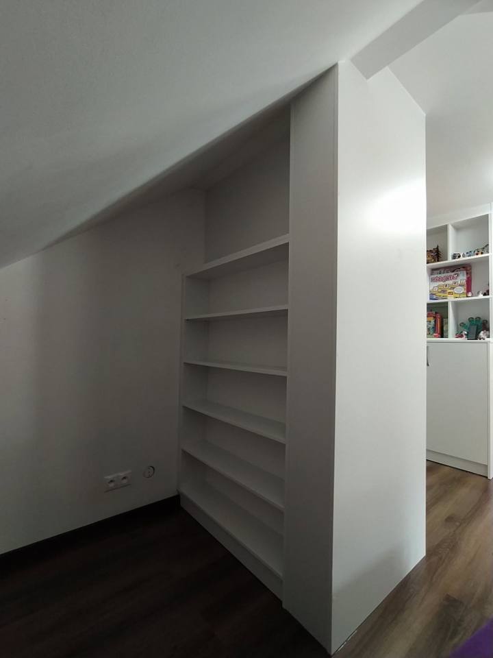 Weißes Regalelement unter der Dachschräge im Dachzimmer