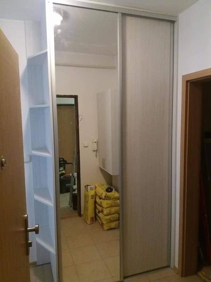 Schwebetürenkasten im hellen Dekor mit weißen Regalen im Vorzimmer