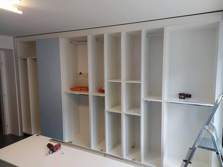 Korpus des Einbaukastens mit Regalen und Stangen bei der Montage