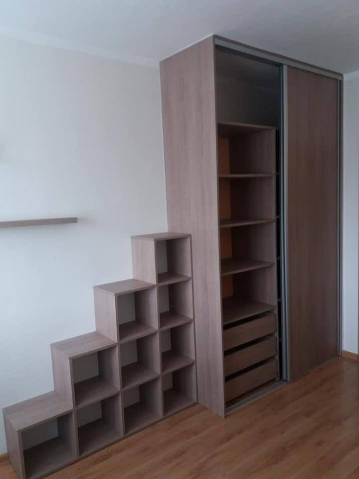 Schiebetürkasten mit stufenförmigem Würfelregal in Eichendekor neben der Stiege.