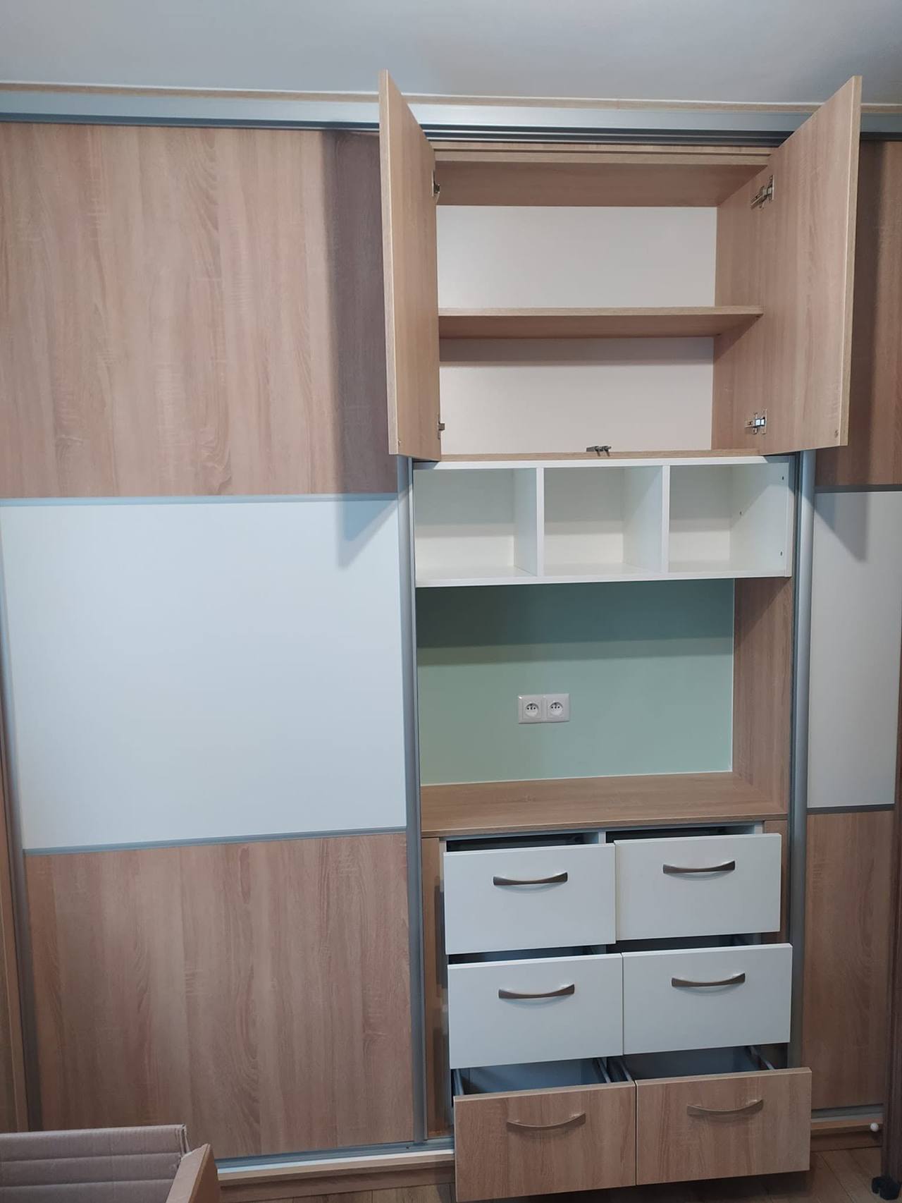 Mittelteil mit geöffneten Drehtüren, offenen Fächern und weißen Laden