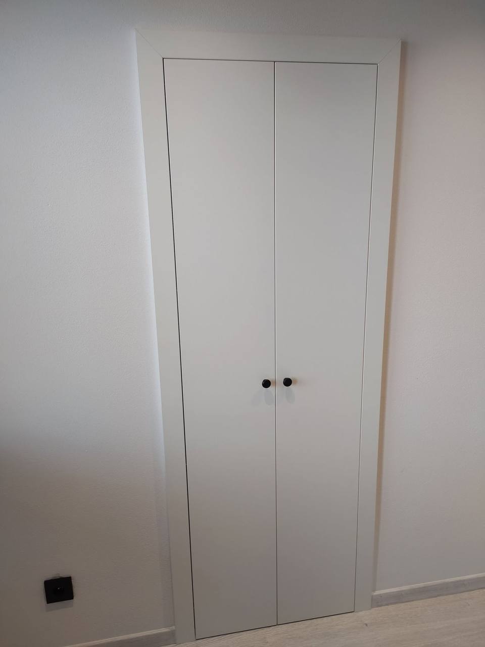 Weiße versteckte Kastentür bündig in der Wand