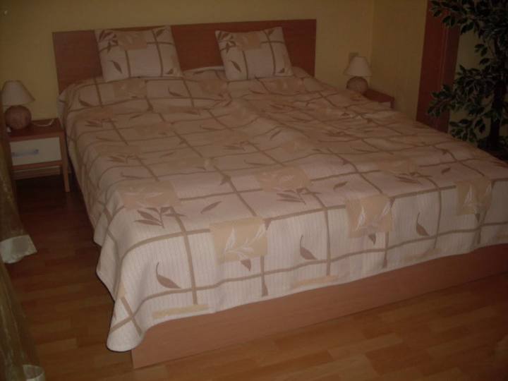 Doppelbett im warmen Dekor mit Nachtkästchen