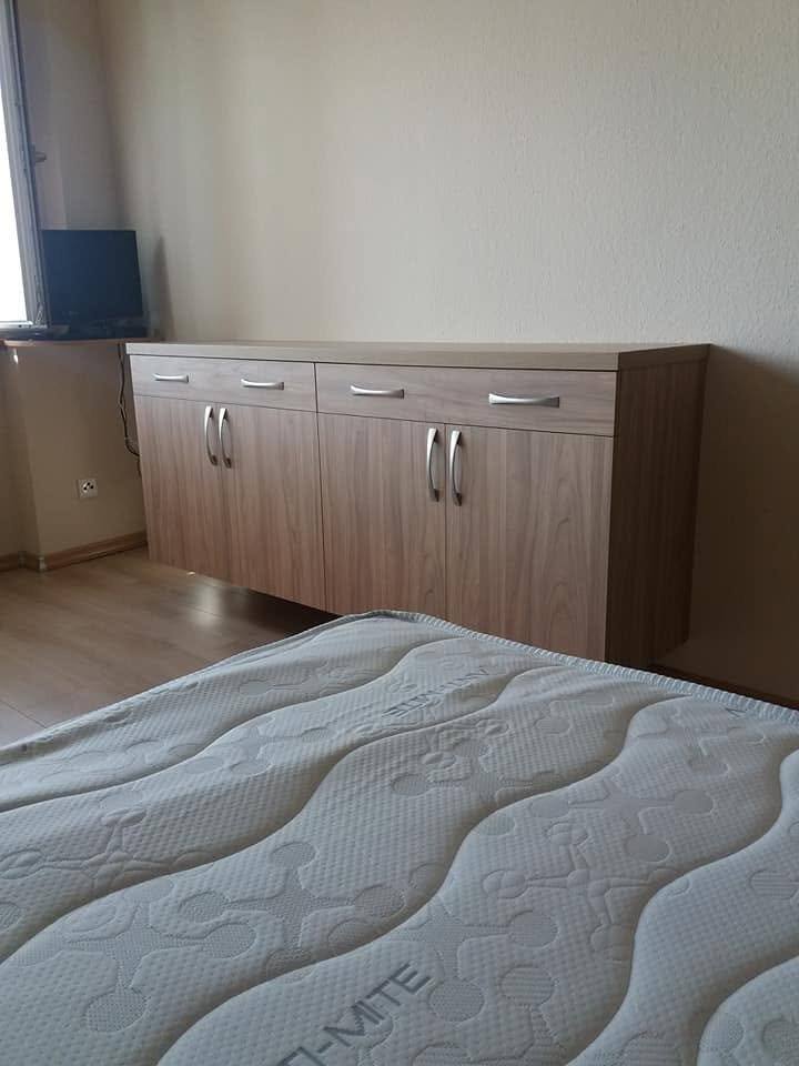 Lange Kommode mit Laden und Türen im Schlafzimmer beim Bett