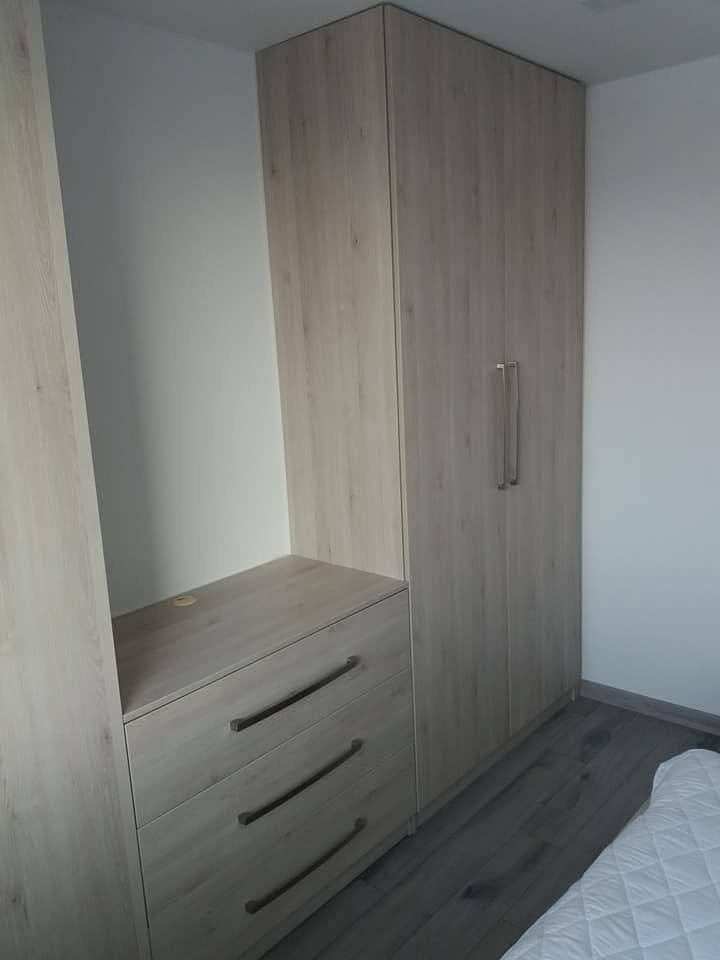 Šatníková skriňa v dekore sivý dub so zásuvkovou komodou v spálni