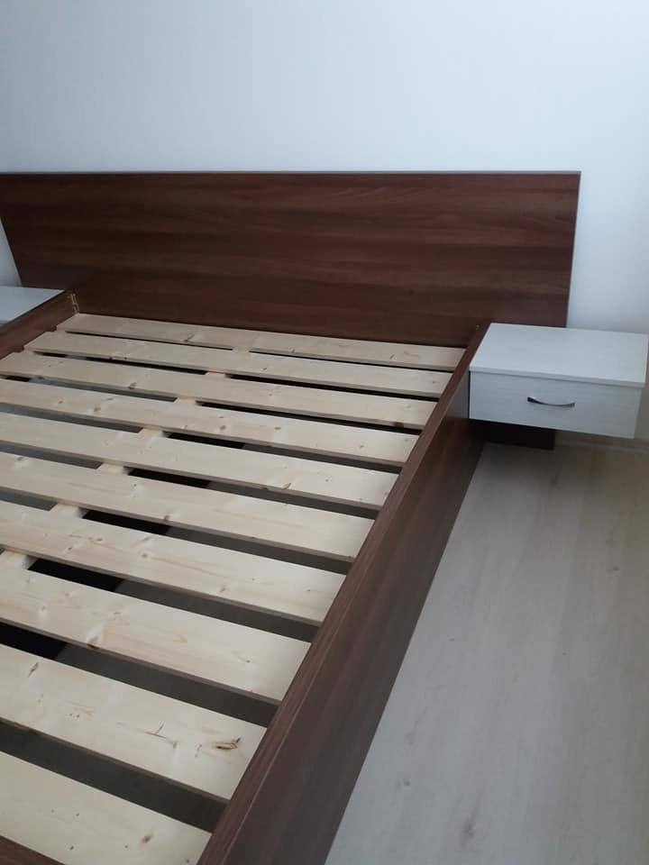 Bett mit hohem Kopfteil und Nachtkästchen in Nussbaumoptik