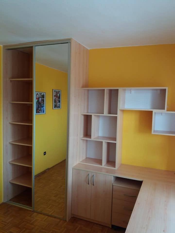 Offene Regalsäule neben dem Kasten und asymmetrische Regale über dem Tisch