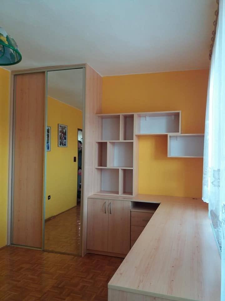 Spiegel-Schiebetürkasten und Regalwand an der orangen Wand